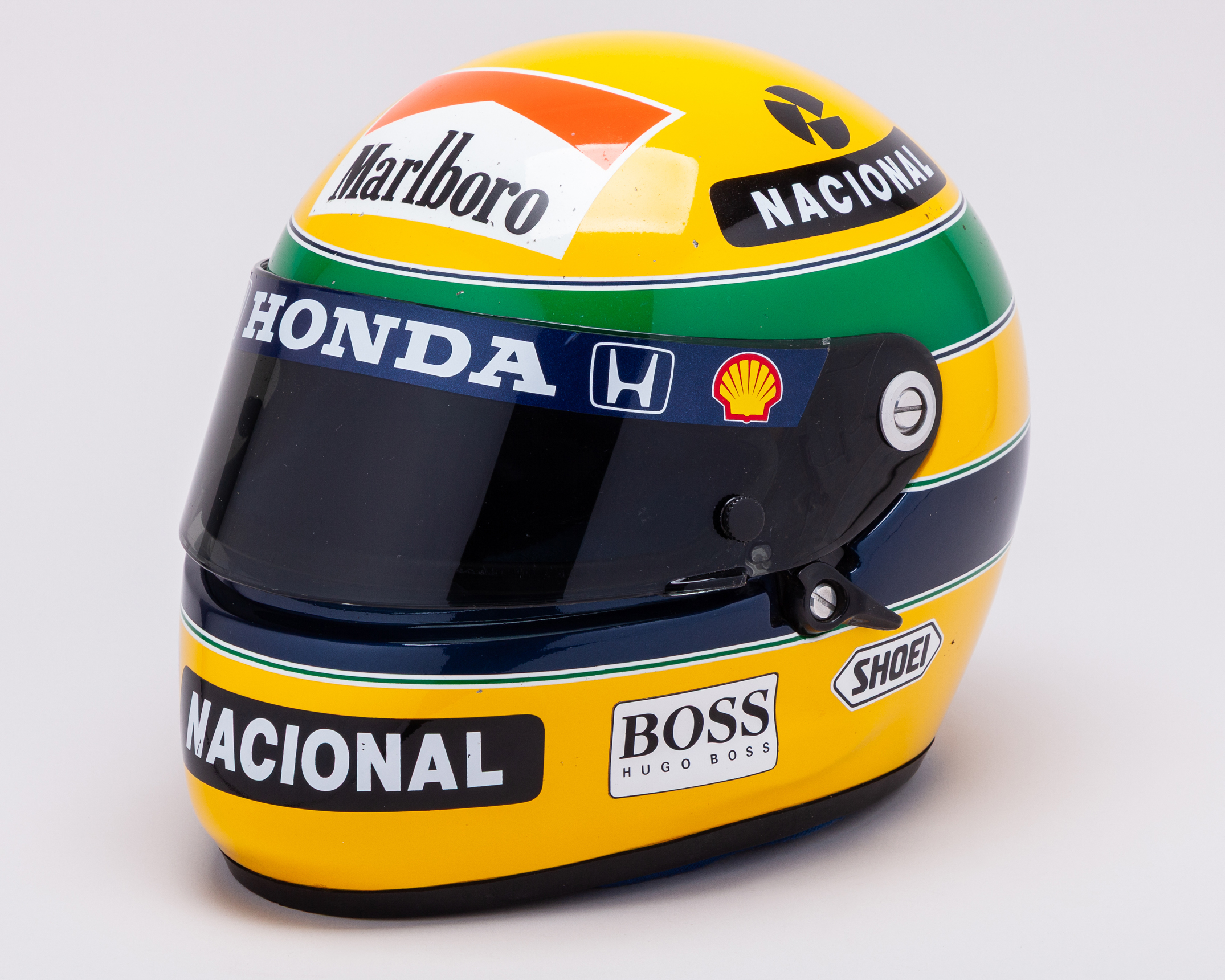 The Green and Yellow helmet worn by Ayrton Senna on a white background