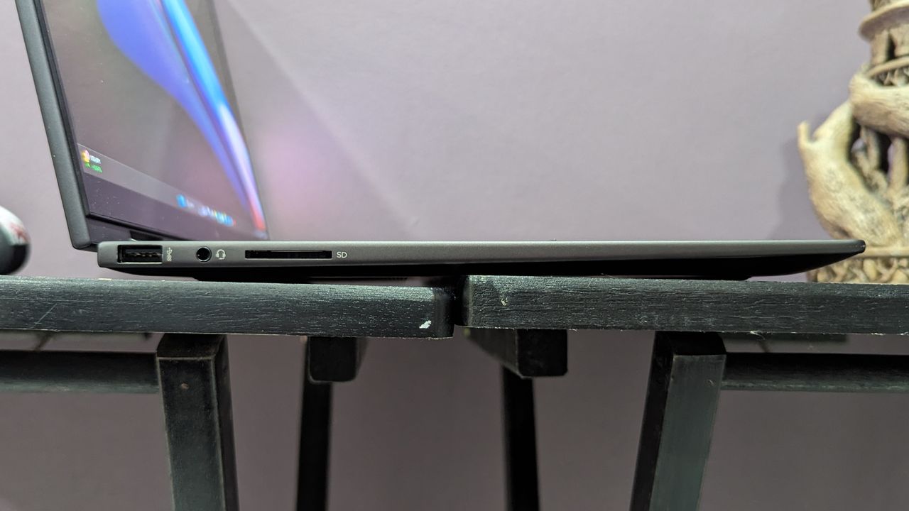 Side-on photo of the HP Envy x360's left-side ports, on a black desk.