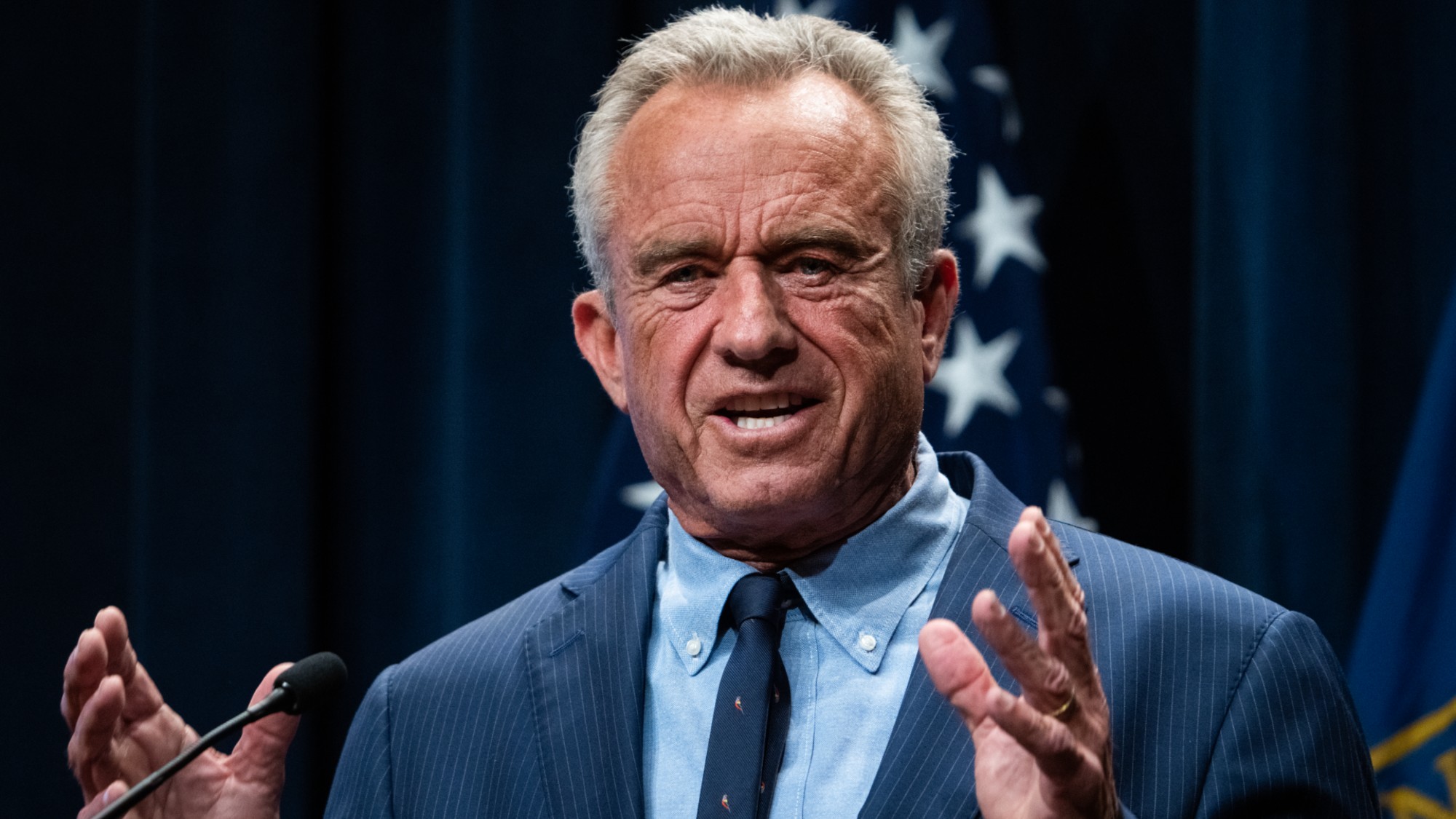 Health and Human Services Secretary Robert F. Kennedy, Jr., in a blue suit with his hands raised