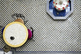 A tiled table and fountain on top of a tiled floor in a courtyard in Morocco