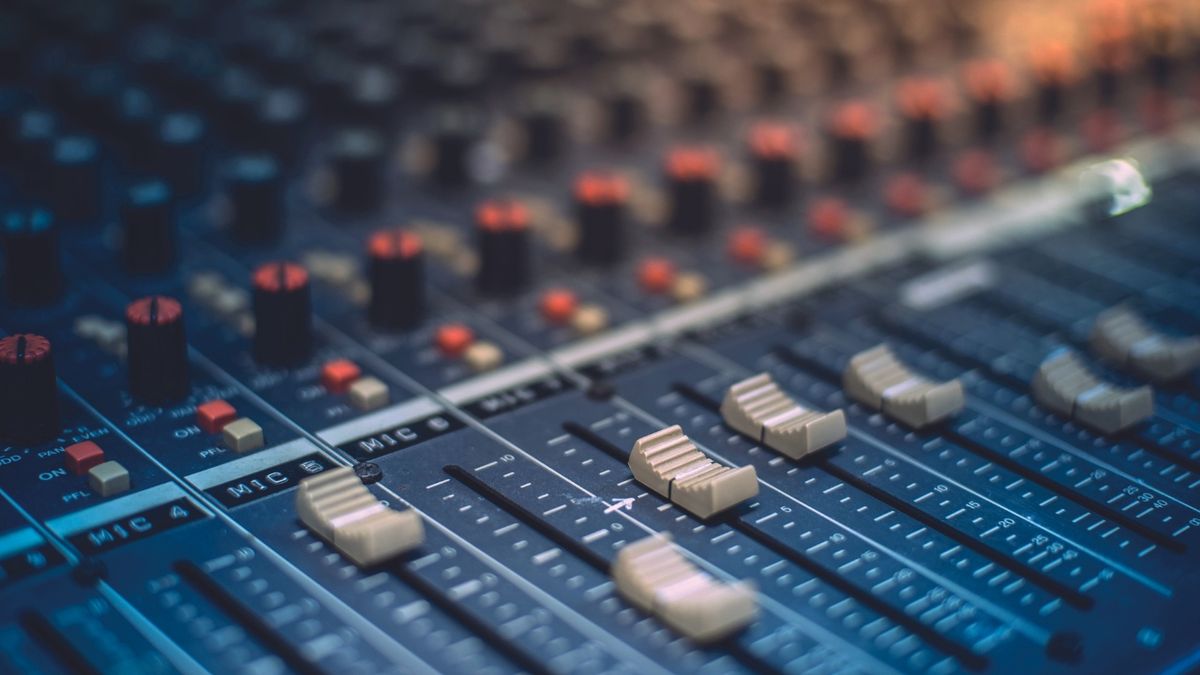 Close up of the sliders on a mixing desk