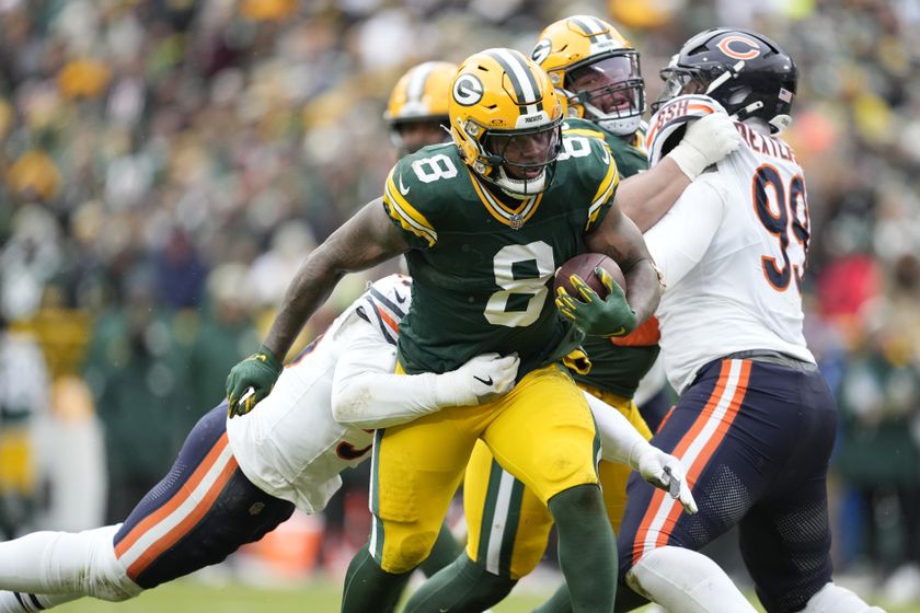 Green Bay Packers player is tackled by a Chicago Bears player during an NFL game