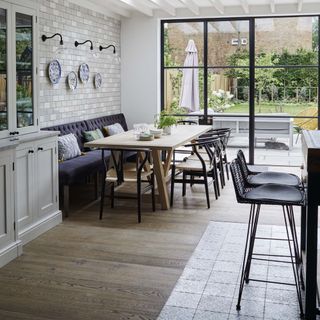 Kitchen with dining table on wooden floor and island on tiled floor