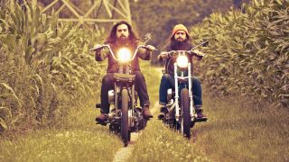 A press shot of the picturebooks riding motorcycles in a field