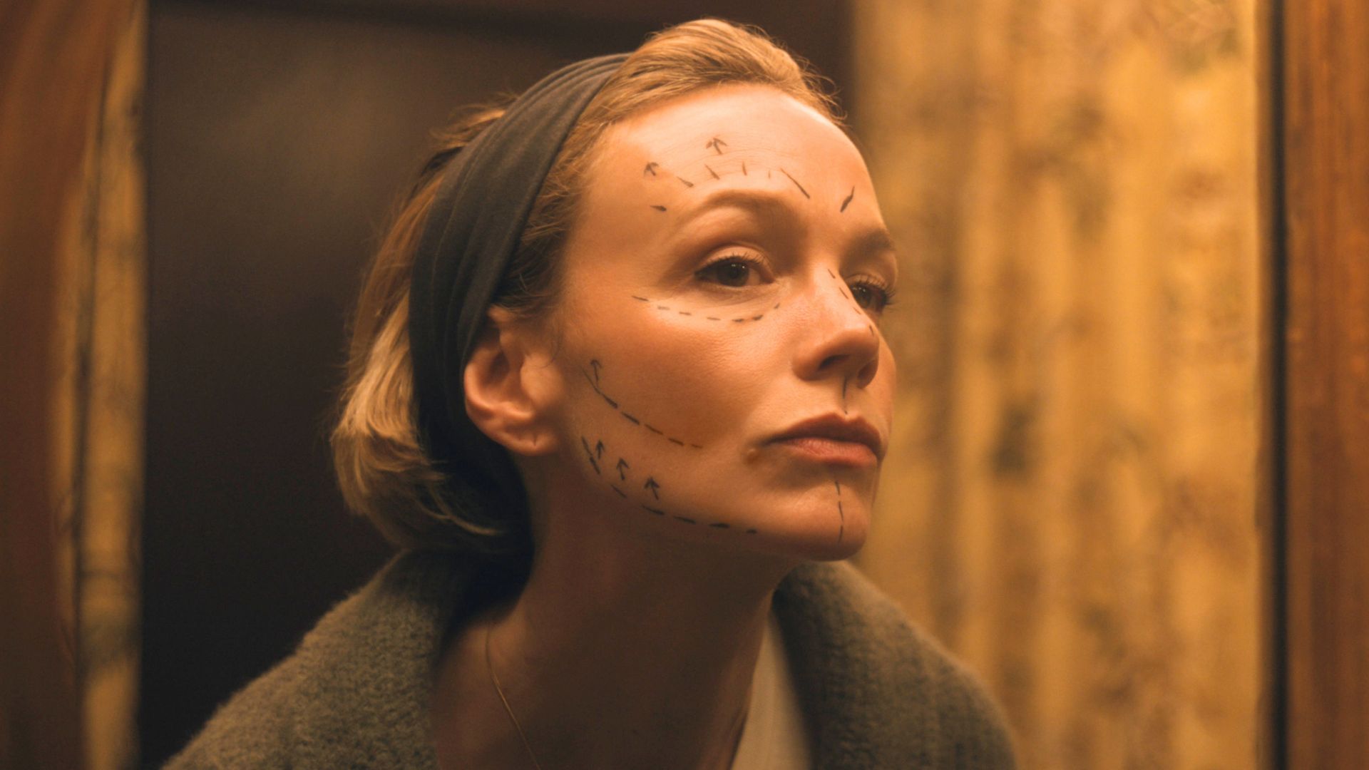 Carey Mulligan looks in the mirror at surgery marks on her face