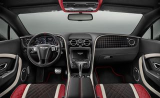 The interior view of the Continental Supersports Bentley. The interior is all black, with accents of red and beige.