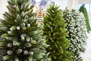 A variety of faux Christmas trees in a store.