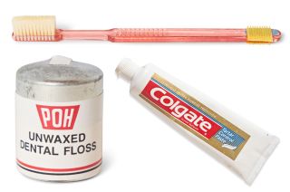 a toothbrush, a tube of toothpase and a packet of dental floss