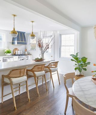 White kitchen with peninsular island and blue range hood