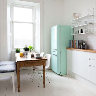 Kitchen diner with table and chair with turqoise fridge