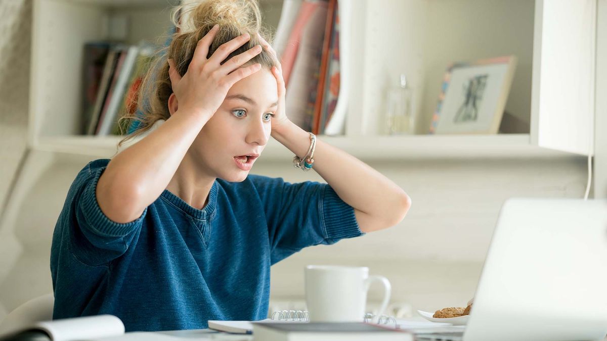 A shocked woman wishing she know how to recall an email in Outlook