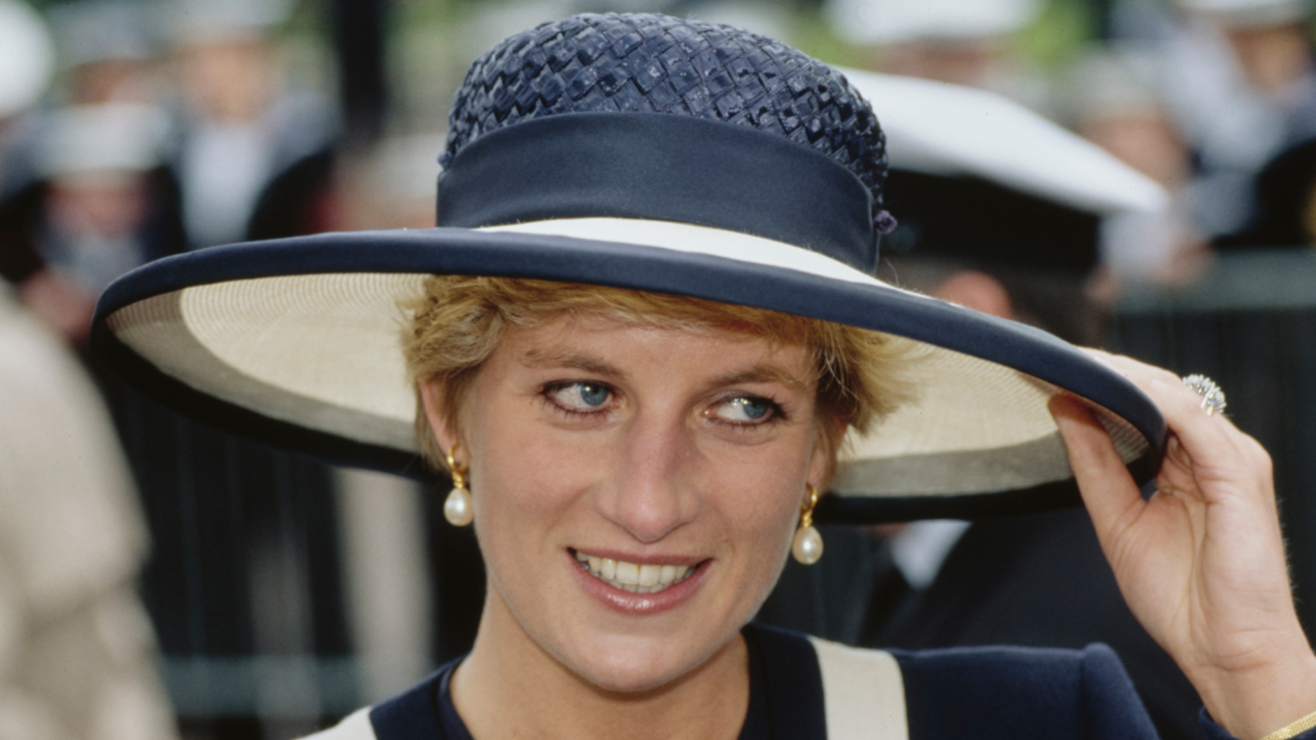 Princess Diana wearing a navy and white hat and matching outfit