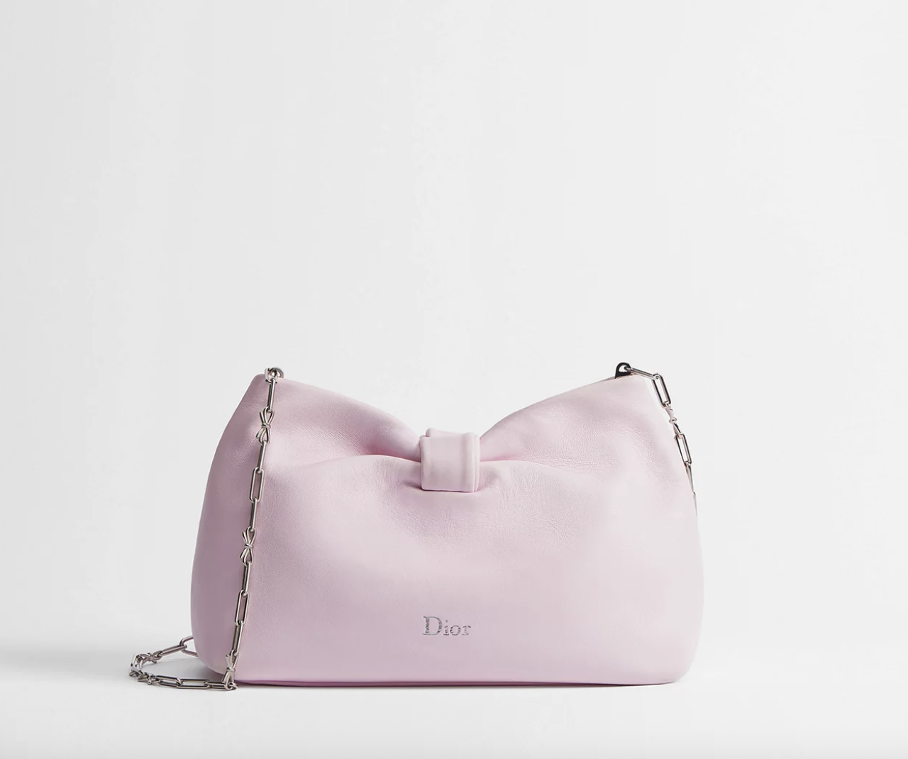 a Dior bow bag on a plain backdrop