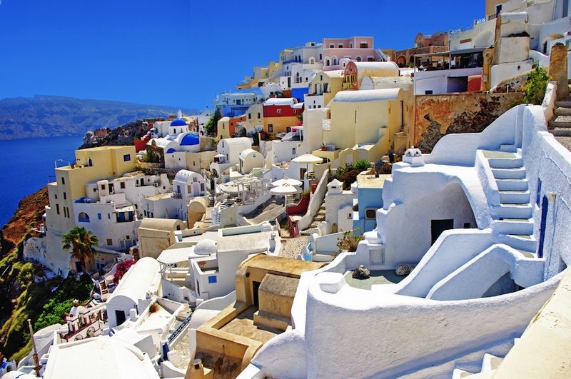 Buildings crowd a steep oceanside cliff on Santorini.