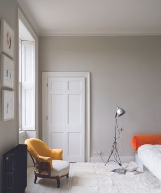 neutral bedroom walls with yellow chair and silver floor lamp