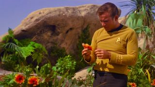 Kirk looking at a flower