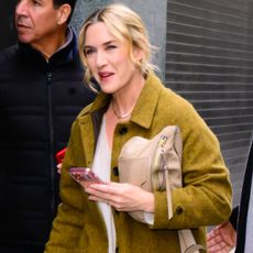 Kate Winslet wears a green coat
