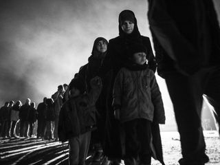 Refugees stand in line to get food in Idomeni, Greece (© Enri Canaj / Magnum Photos)