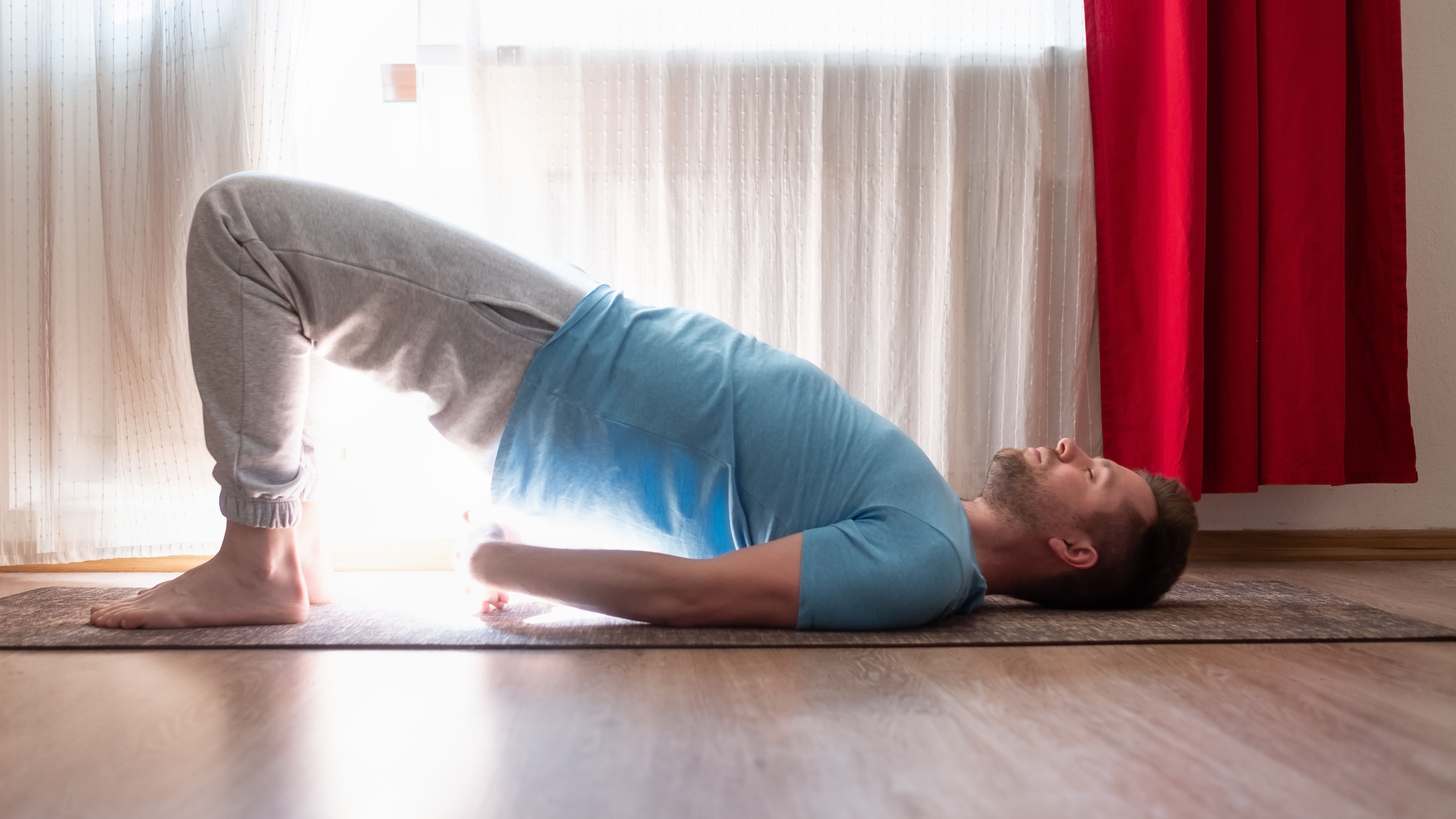 Man doing bridge pose at home