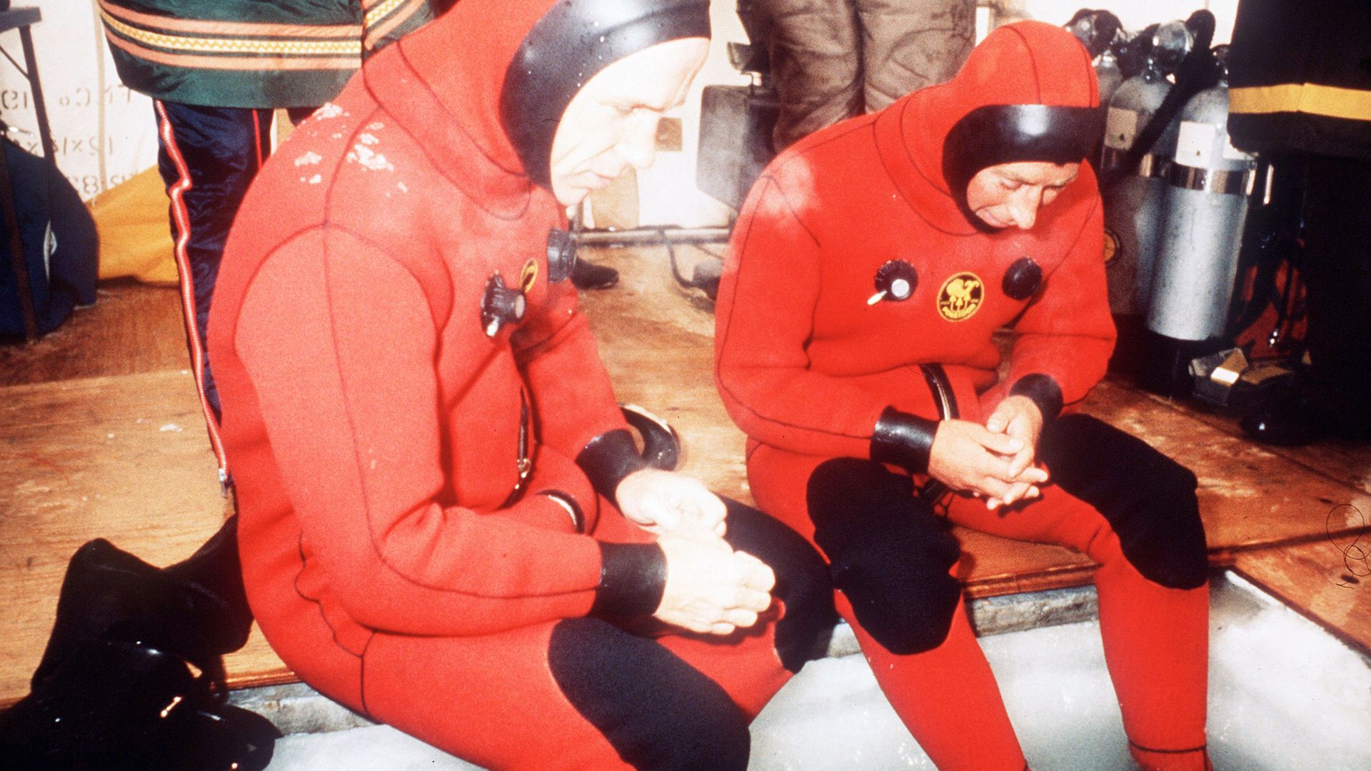 King Charles wears a special diving suit as he attempts to walk below the five-foot arctic ice during a visit to the Northwest Territories in April 1975