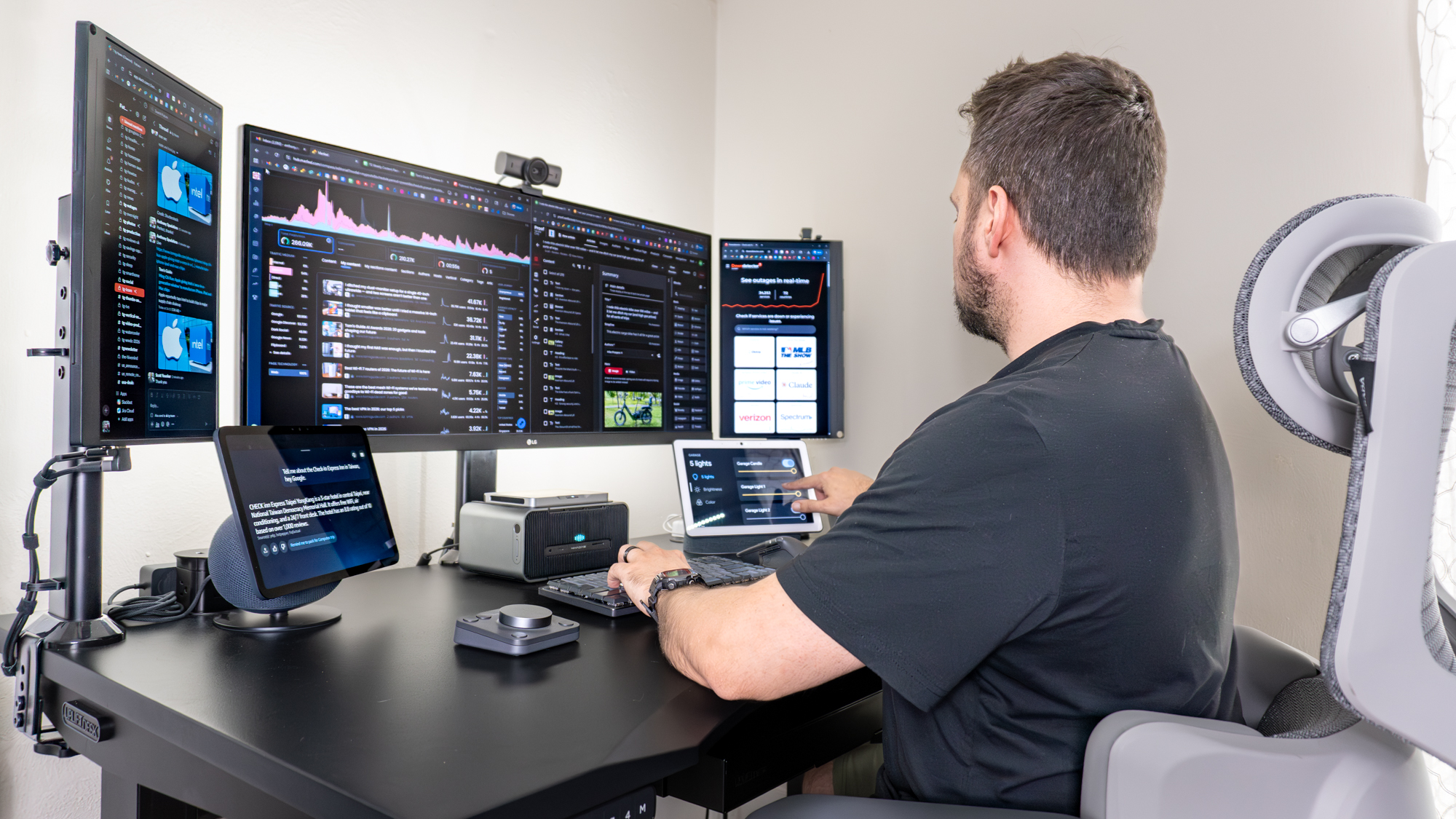 A person working at a desk with a triple monitor setup with a smart display on either side