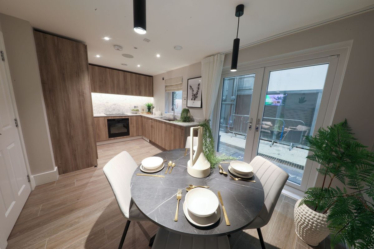 A veneer kitchen inside the home with a table and chairs at the forefront of the image