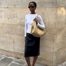 Sylvie wearing a white top, black skirt and yellow skirt