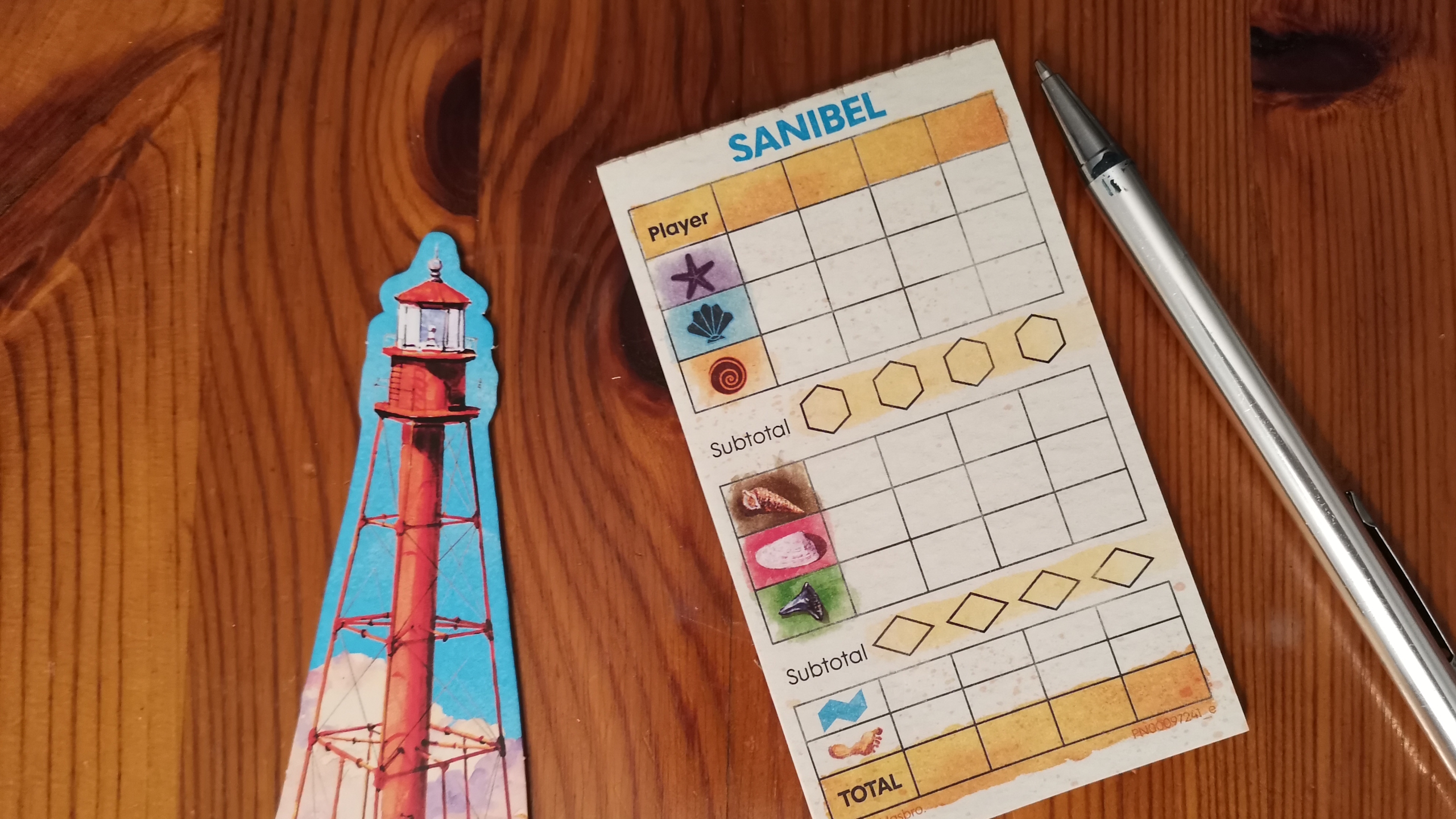 Sanibel board, tokens, and pieces on a wooden surface