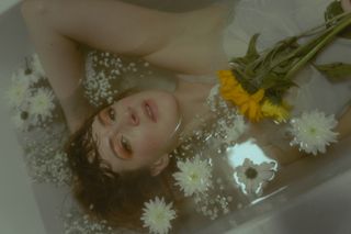 portrait of a girl in a bath surrounded by flowers