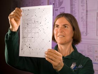 Janice Voss, a scientist who worked on Kepler, studies a field plate, or identifier.