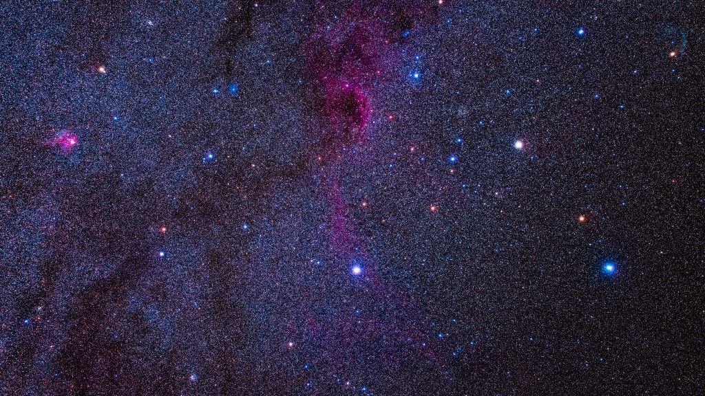 This frames the region of the Milky Way in southern Canis Major and northern Puppis, rich in a variety of star clusters and some nebulosity. The field of view is 15º by 10º. At right the brightest stars are in Canis Major: yellow-white Wezen (Delta Canis Mjaoris) and blue-white Adhara (Epsilon Canis Majoris), with orange Sigma Canis Majoris between them. Above left of Wezen is the large cluster NGC 2354, and above it the smaller and brighter NGC 2362. At top left is a Messier cluster, M93, in Puppis. At far left is the bright magenta emission nebula NGC 2467. At lower left near the frame edge is the cluster NGC 2489. At bottom is the cluster NGC 2439, while the group of stars at bottom centre is the cluster Collinder 140, a distinctive object in binoculars. I call it the J Cluster as it looks like a letter J. The large diffuse faint nebulosity at top is Sharpless 2-310, though wisps of emission nebulosity extends down past the star Aludra, Eta Canis Majoris, below centre. At upper right near the orange star Omicron Canis Majoris is the faint cyan arc of the large planetary nebula Sharpless 2-308, aka the Dolphin Head Nebula, barely visible here. Left of the big Sharpless emission nebula is a small blue reflection nebula van den Burgh 98. Above the NGC 2362 cluster at the top of the frame is another small blue reflection nebula, van den Burgh 96. 