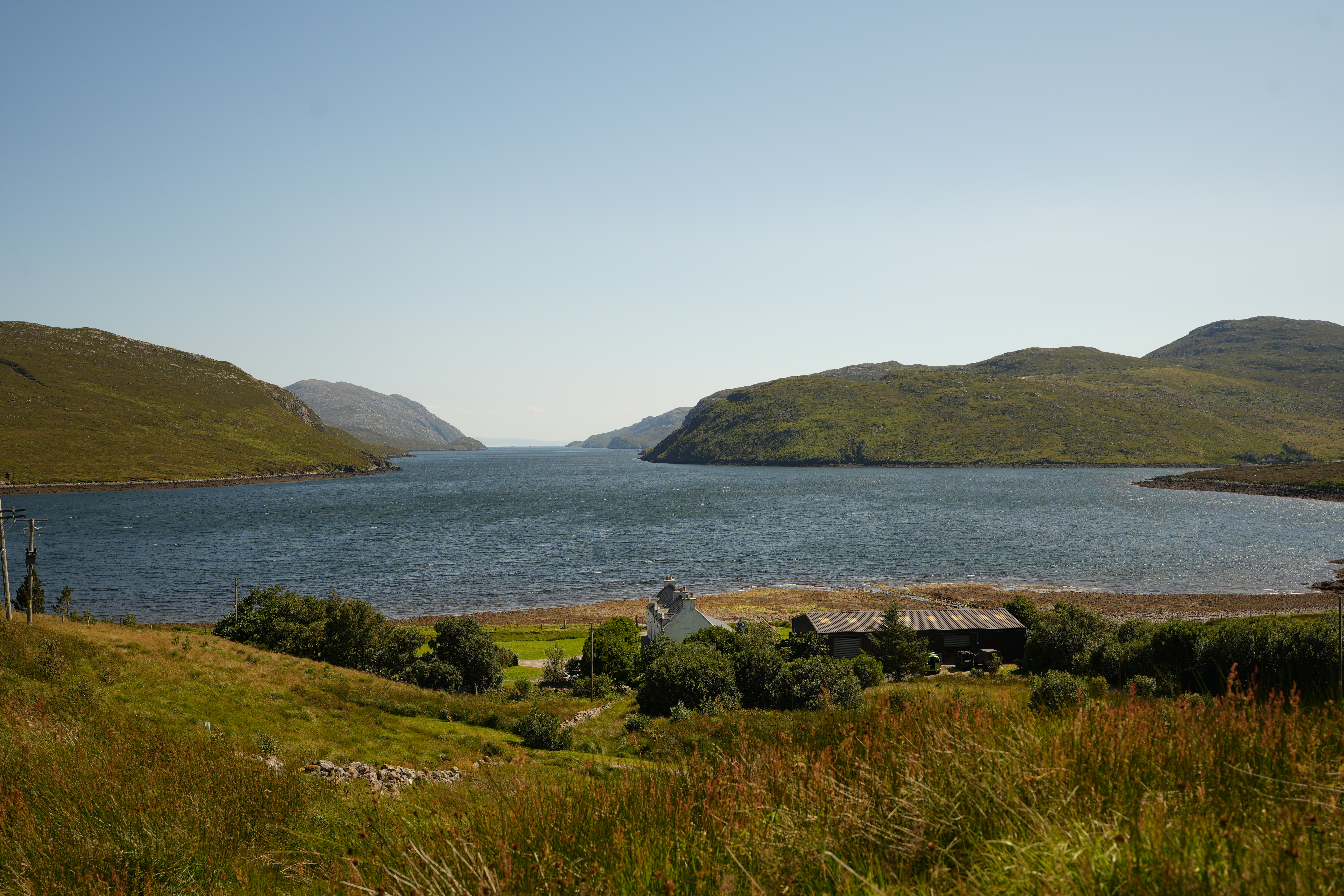 A beautiful landscape with rolling green hills and a blue loch