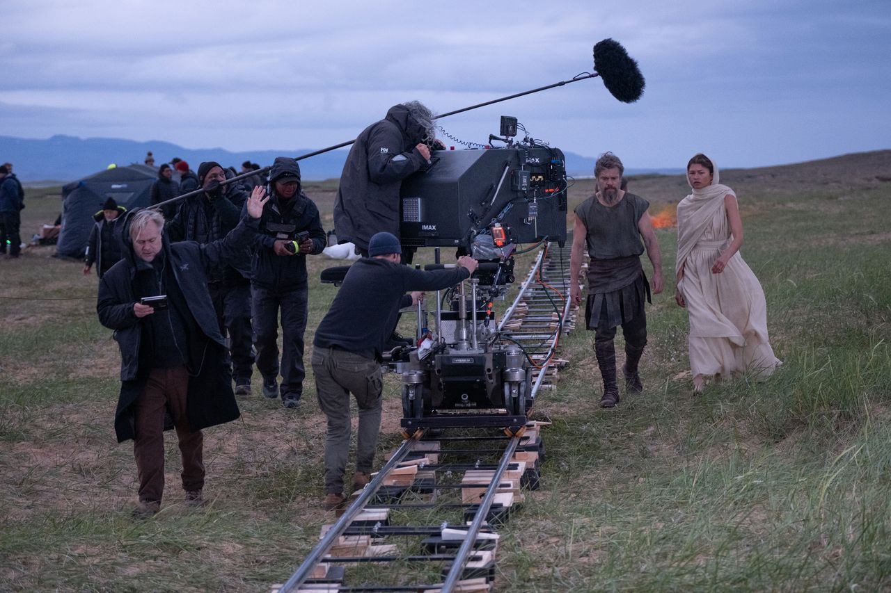 A series of set shots of actors dressed in period clothing, filming along rugged coasts, tranquil sandy beaches, and rocky fortresses.