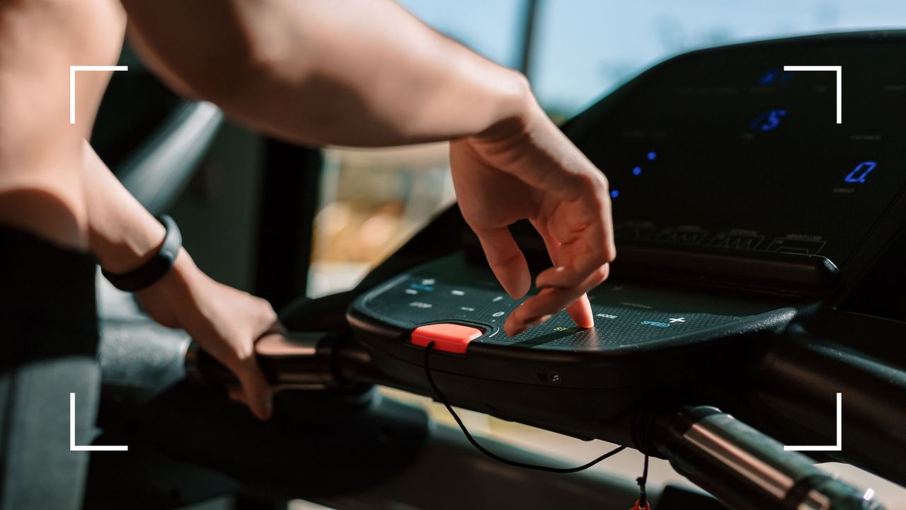 Woman&#039;s hands pressing buttons to start treadmill at the gym, representing 12-3-30 workout 