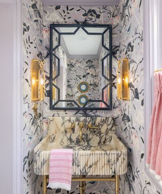 Powder room with ornate wallpaper and marble sink by Paige Loperfido at Decor & More Design Studio