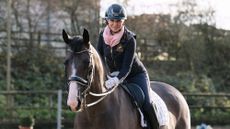 Dressage rider Louise Bell pats her rising star dressage horse Peaky Blinder on the neck as they both look at the camera during a magazine shoot at home