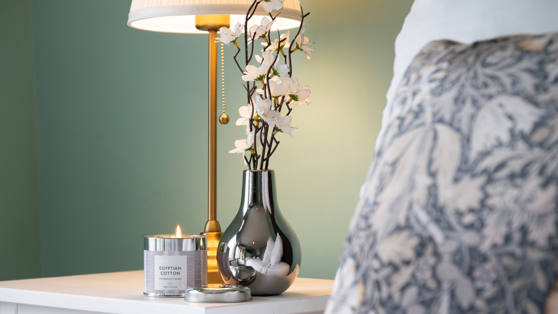 Chintz cushion and beside table with flowers