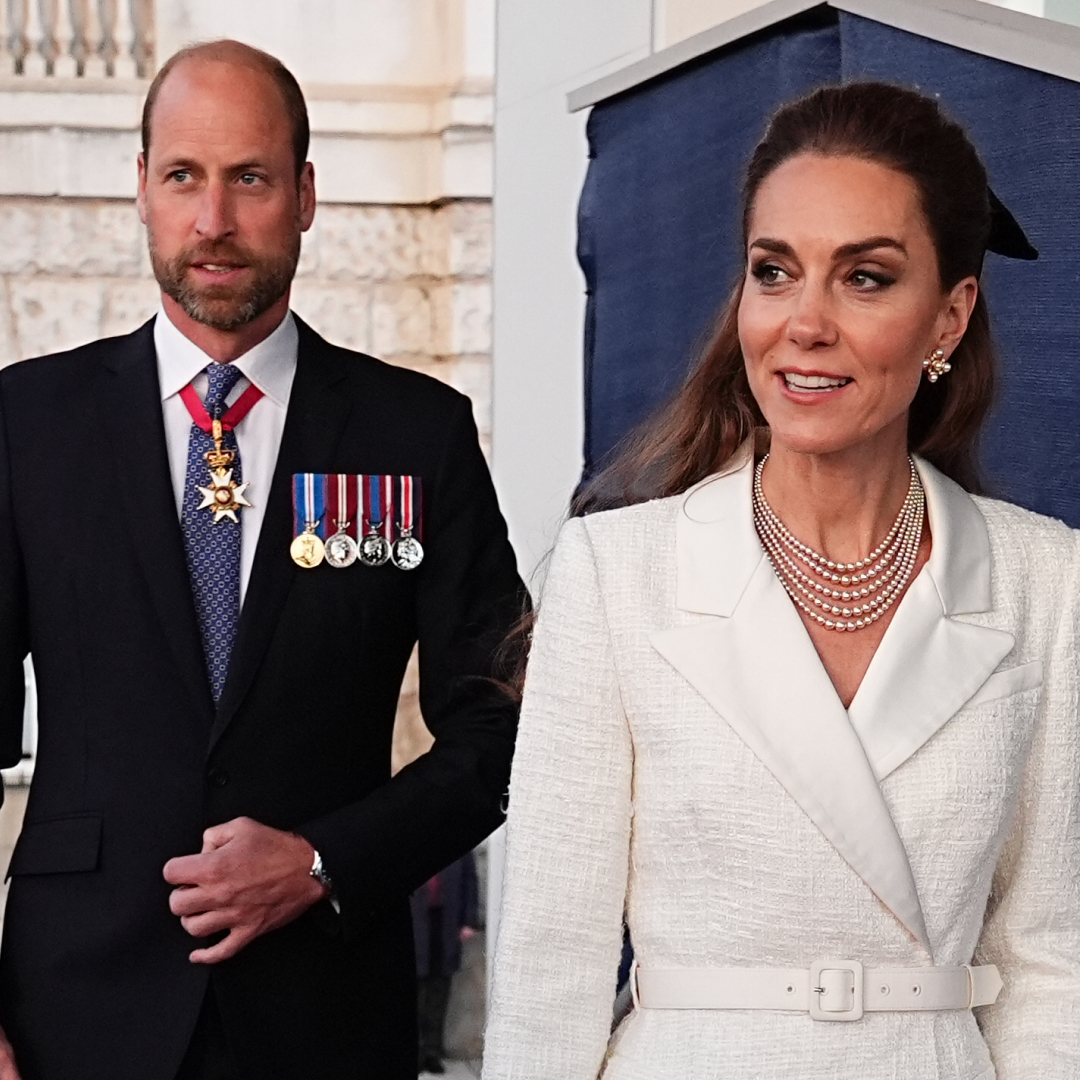 Prince William wears a suit and military medals and Kate Middleton wears a cream coat dress with a floppy black bow