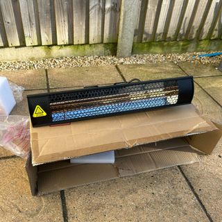 Gtech HeatWave Patio Heater on cardboard packaging box on patio in garden