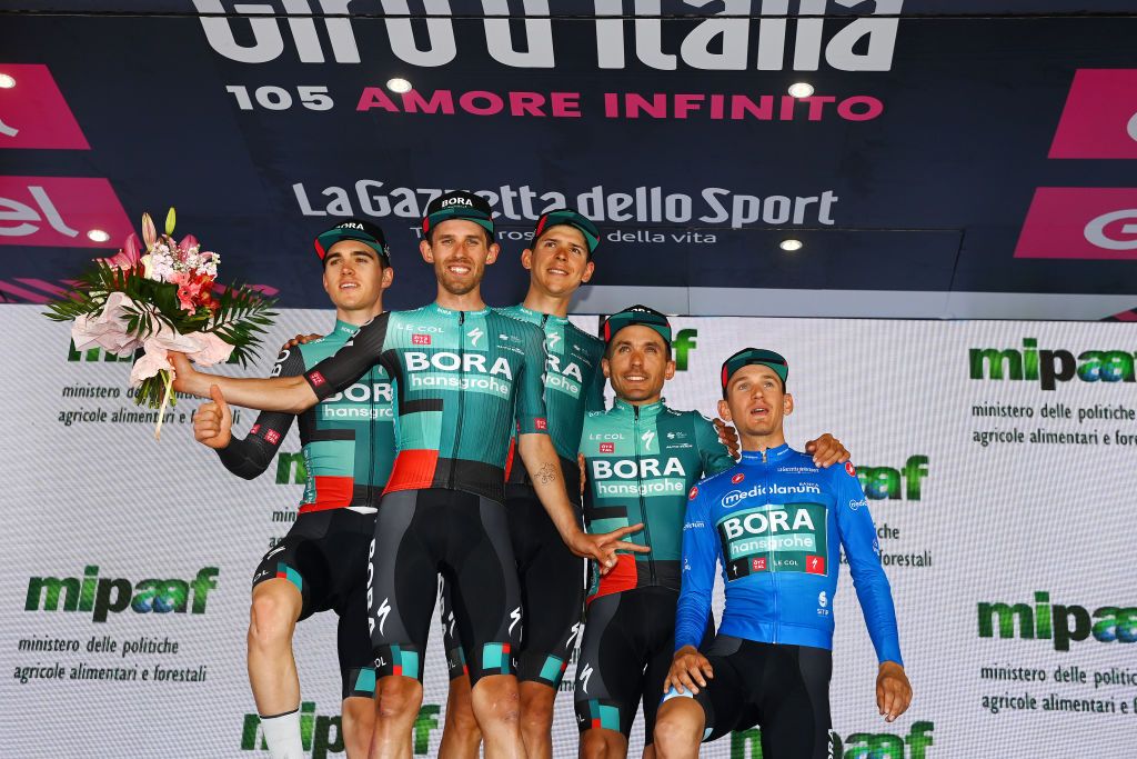 MESSINA ITALY MAY 11 LR Giovanni Aleotti of Italy Ben Zwiehoff of Germany Patrick Gamper of Austria Cesare Benedetti of Poland and Lennard Kmna of Germany and Team Bora Hansgrohe blue mountain jersey celebrate winning the super team trophy on the podium ceremony after the 105th Giro dItalia 2022 Stage 5 a 174km stage from Catania to Messina Giro WorldTour on May 11 2022 in Messina Italy Photo by Tim de WaeleGetty Images