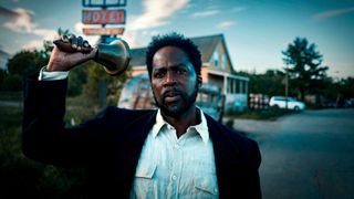 Harold Perrineau as Boyd Stevens rings a bell in front of a dilapidated motel in From