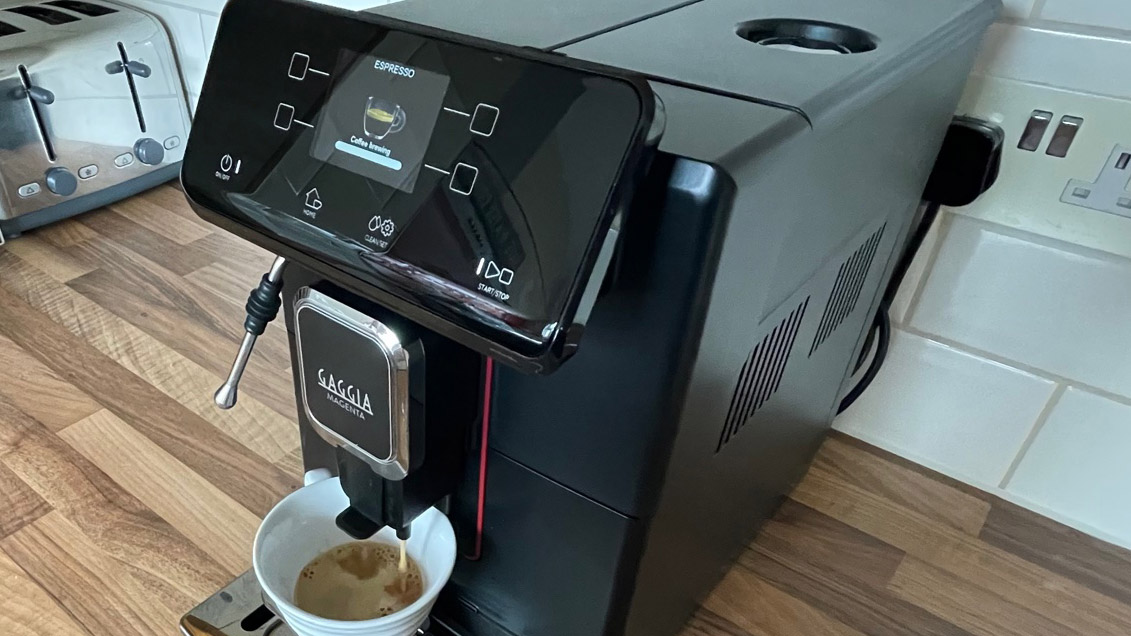 The side view of the Gaggia Magenta Plus while its brewing espresso