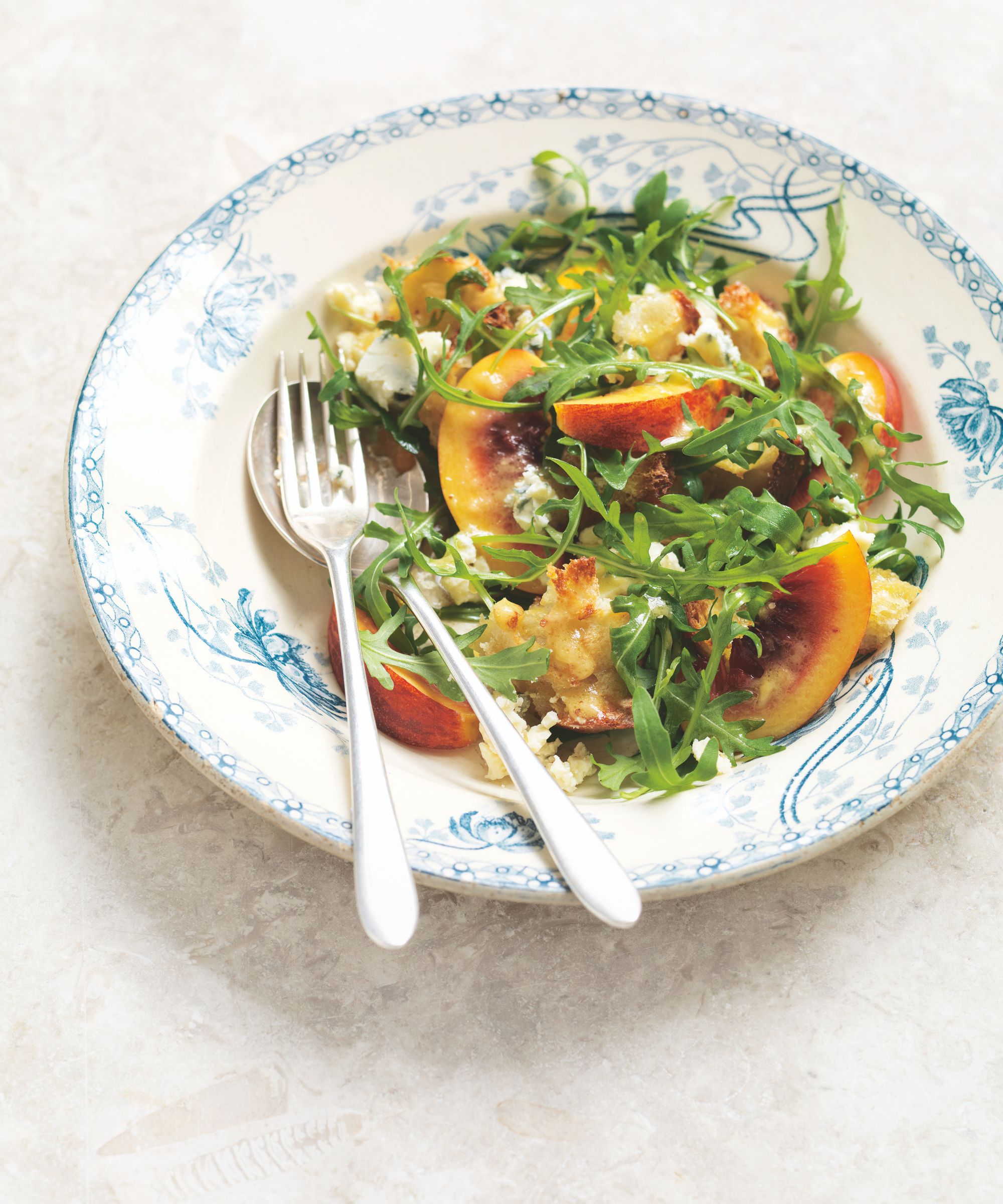 blue cheese, nectarine and rocket salad in a blue and white bowl