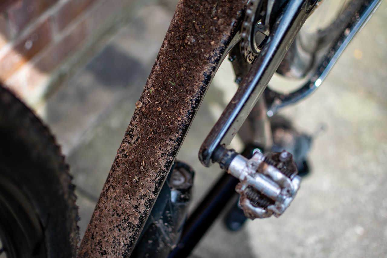 A down tube of a gravel bike covered in mud