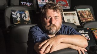 A portrait of Ben Wheatley with his records in a cinema