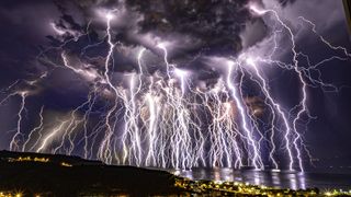 Hundreds of lightning bolts illuminate the night sky during thunderstorm