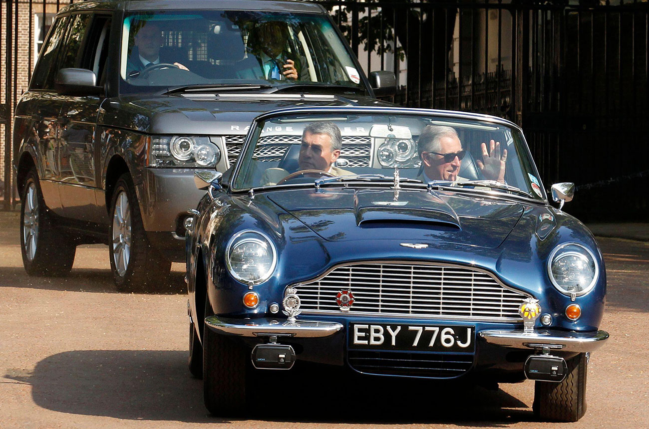 Prince Charles being driven in his Aston Martin, which runs on fuel partly made from wine leftovers.