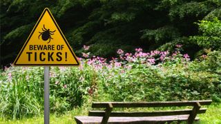 How to avoid tick bites: sign saying "beware of ticks"