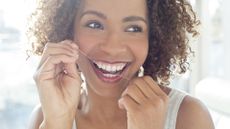 How often should you floss? image shows woman flossing teeth