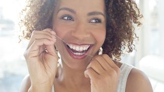 How often should you floss? image shows woman flossing teeth